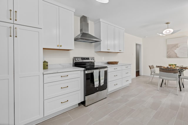 kitchen featuring wall chimney exhaust hood, light stone countertops, stainless steel electric range, and white cabinetry