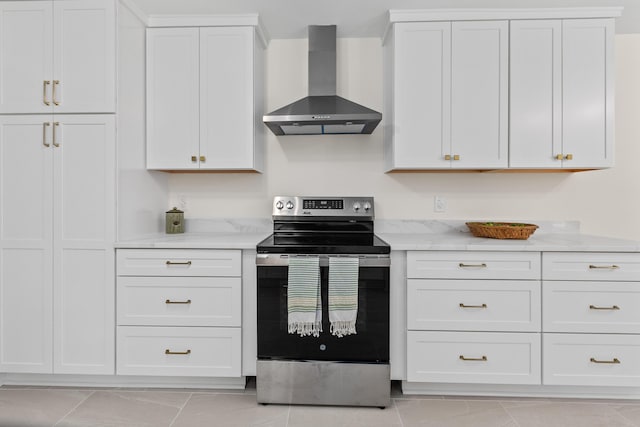 kitchen featuring stainless steel range with electric cooktop, light stone counters, white cabinetry, and wall chimney exhaust hood