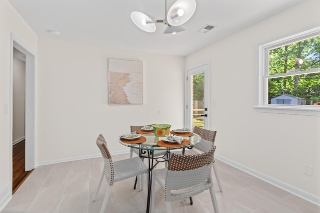 dining area featuring baseboards, plenty of natural light, a notable chandelier, and visible vents