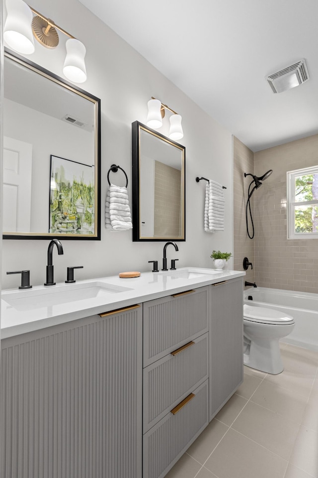 bathroom with visible vents, shower / washtub combination, a sink, tile patterned floors, and toilet