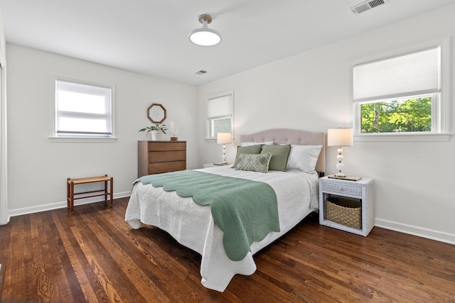 bedroom with multiple windows, wood finished floors, and visible vents