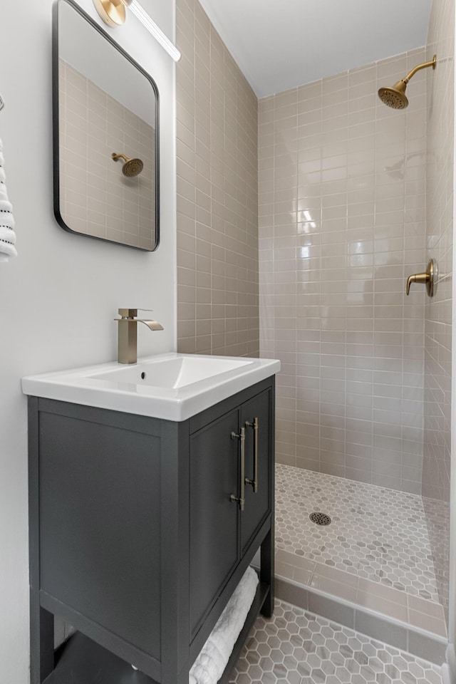 bathroom with tile patterned floors, tiled shower, and vanity