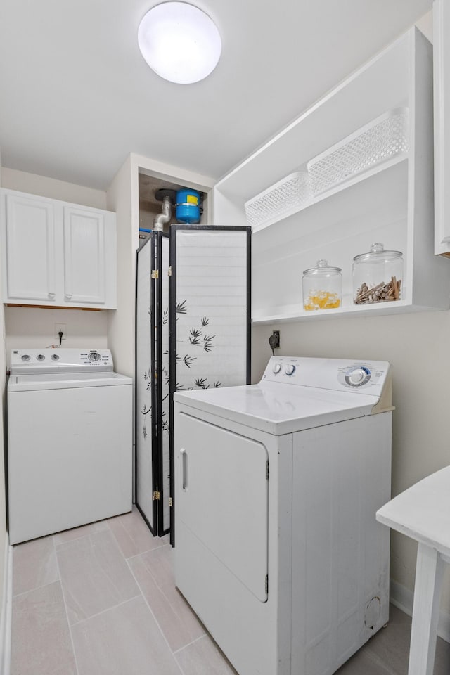 clothes washing area featuring cabinet space and washing machine and dryer