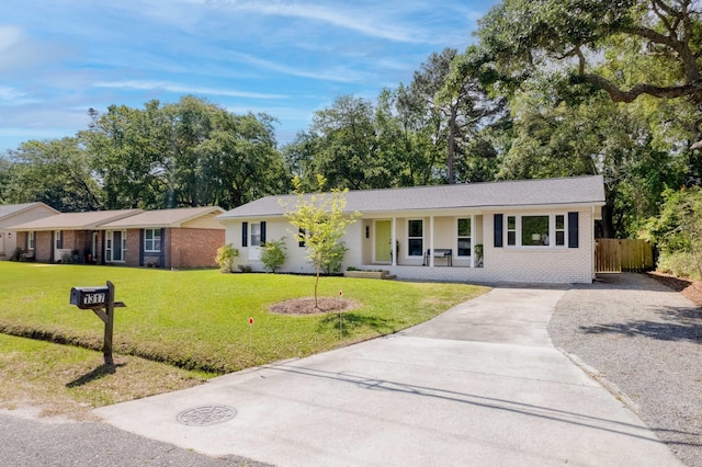 single story home with concrete driveway, a porch, a front lawn, and brick siding