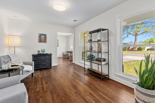sitting room with baseboards, dark wood-style floors, and visible vents