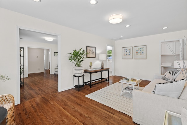 living room featuring baseboards, recessed lighting, and wood finished floors