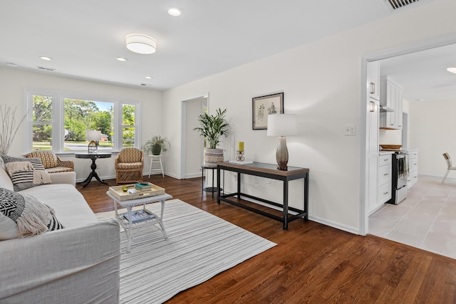 living area featuring recessed lighting, baseboards, light wood-type flooring, and visible vents