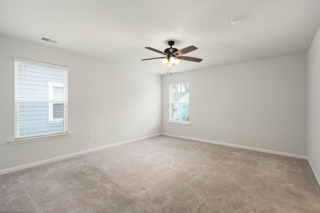 spare room with ceiling fan and light carpet