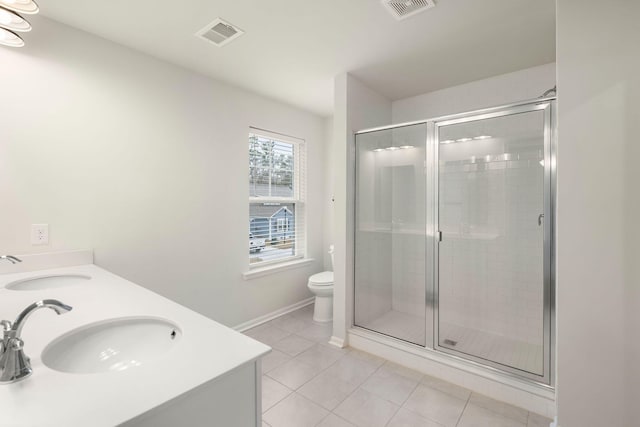 bathroom with tile patterned floors, vanity, toilet, and a shower with shower door