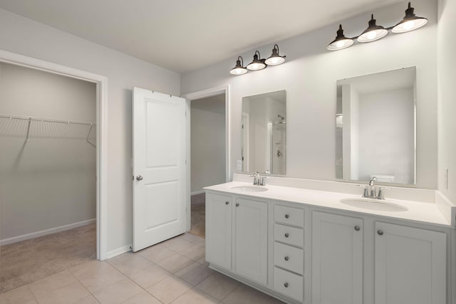 bathroom with a shower, tile patterned flooring, and vanity