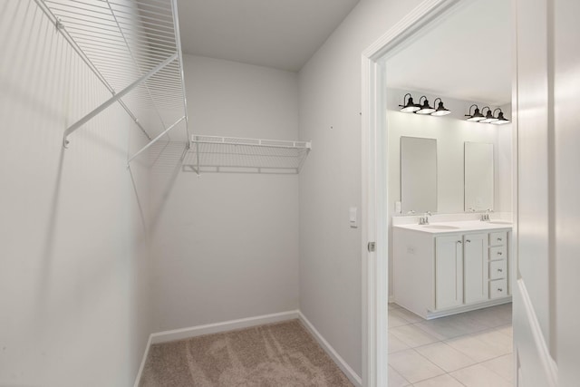 walk in closet featuring sink and light tile patterned floors