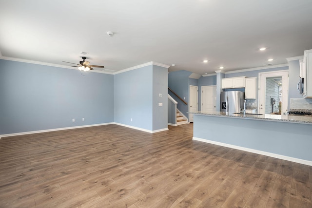 unfurnished living room featuring ceiling fan, light hardwood / wood-style floors, and ornamental molding