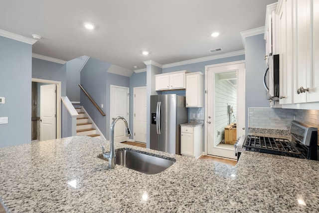 kitchen featuring white cabinets, decorative backsplash, sink, and stainless steel appliances