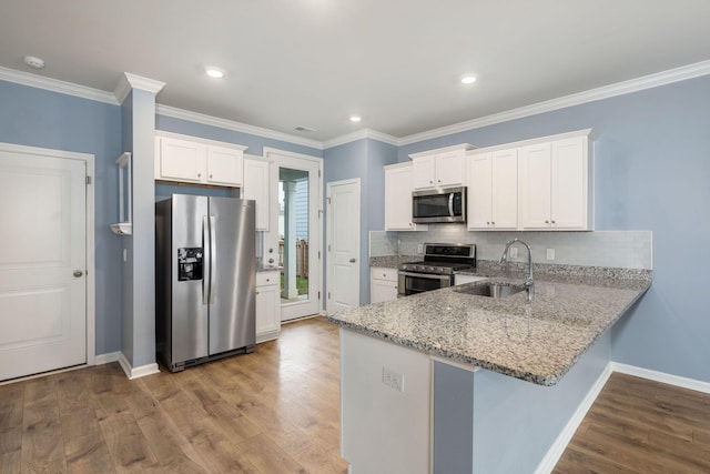 kitchen featuring white cabinets, appliances with stainless steel finishes, crown molding, and sink