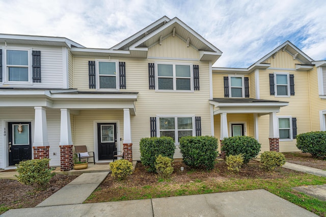 townhome / multi-family property with a porch and board and batten siding