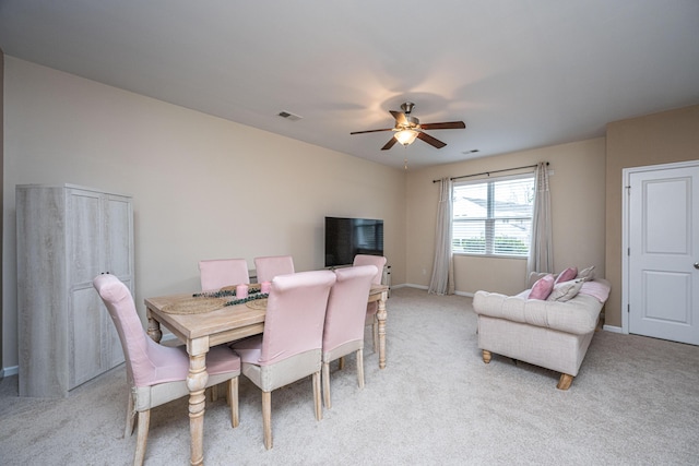 dining area featuring visible vents, light colored carpet, baseboards, and ceiling fan