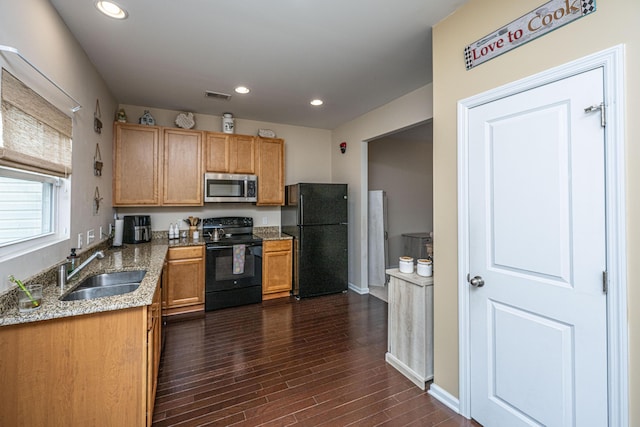 kitchen featuring visible vents, recessed lighting, dark wood-style floors, black appliances, and a sink