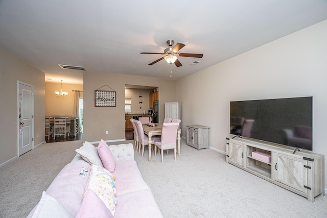 living area with visible vents, baseboards, carpet flooring, and ceiling fan with notable chandelier