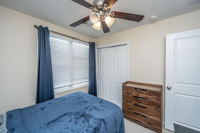 carpeted bedroom featuring a ceiling fan, visible vents, and a closet