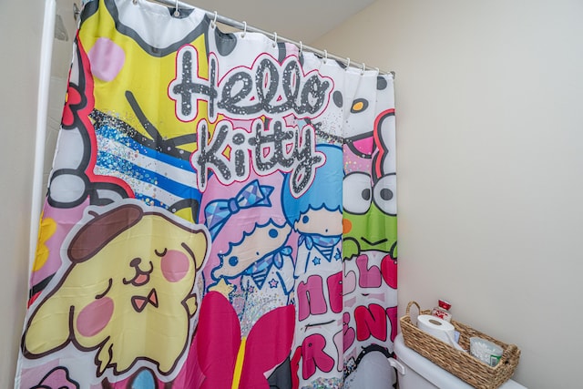 bathroom featuring curtained shower and toilet