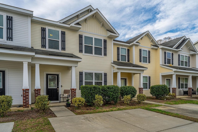 townhome / multi-family property featuring a porch, board and batten siding, and brick siding