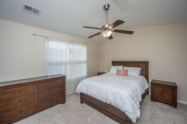 bedroom with ceiling fan, lofted ceiling, visible vents, and light carpet