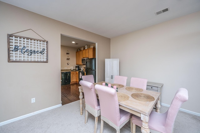 carpeted dining area with bar, baseboards, and visible vents