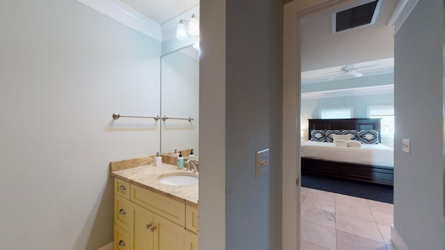 bathroom with ornamental molding, ceiling fan, vanity with extensive cabinet space, and tile flooring