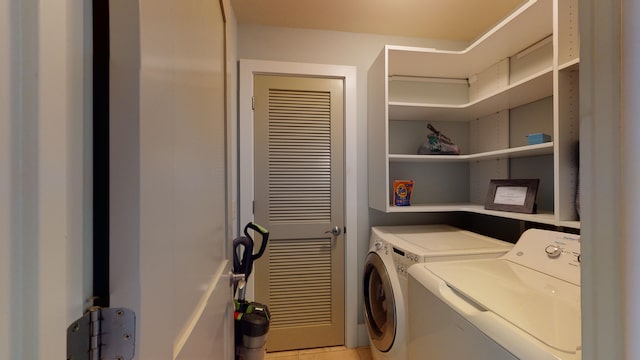 clothes washing area with light tile flooring and washer and dryer