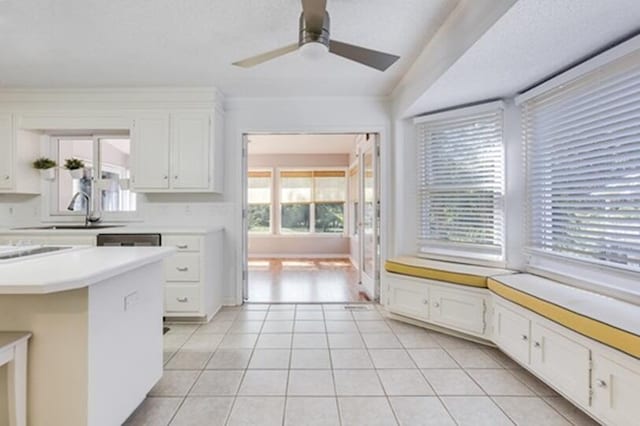 kitchen featuring white cabinets, ceiling fan, sink, and light tile patterned floors