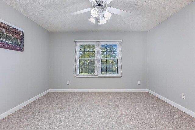 carpeted spare room featuring a textured ceiling and ceiling fan