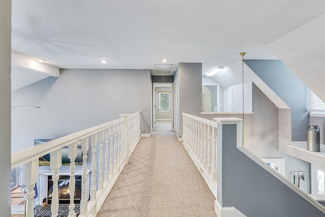 hallway with carpet flooring and a textured ceiling