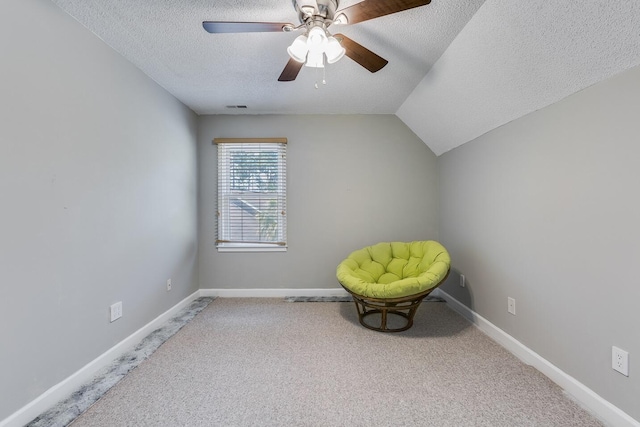 unfurnished room featuring ceiling fan, a textured ceiling, vaulted ceiling, and carpet