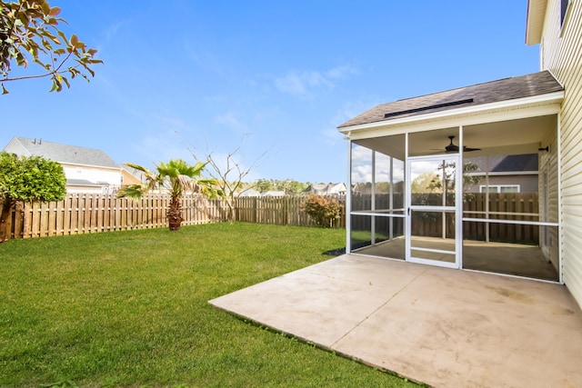 view of yard with a sunroom, a ceiling fan, and a patio