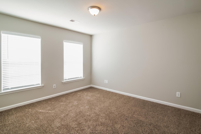 spare room featuring carpet floors and baseboards