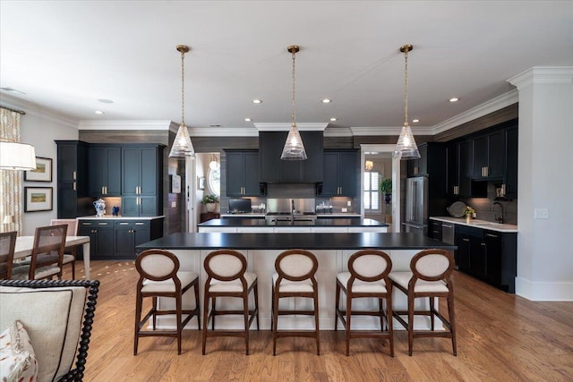 kitchen featuring high end refrigerator, a healthy amount of sunlight, and a sink
