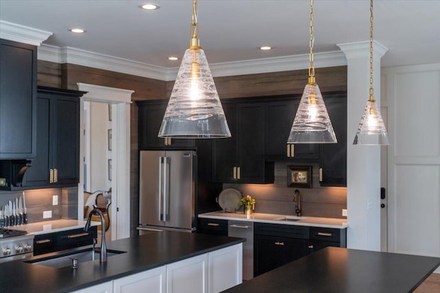 kitchen with stainless steel appliances, decorative light fixtures, a sink, and dark countertops