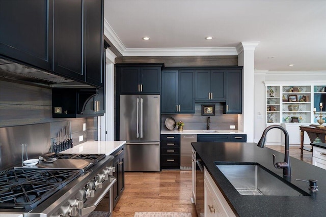 kitchen featuring decorative backsplash, crown molding, premium appliances, and a sink