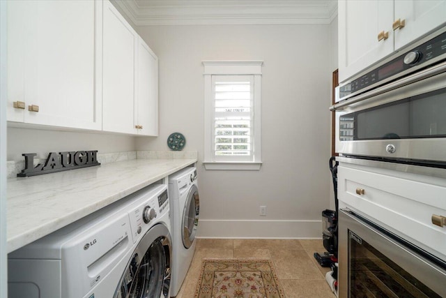 clothes washing area featuring independent washer and dryer, baseboards, ornamental molding, and laundry area