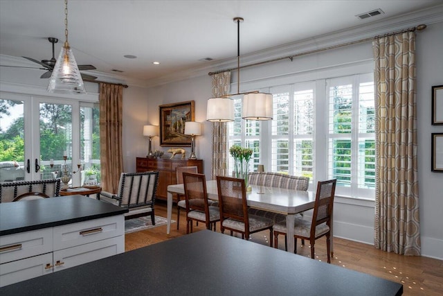 dining space featuring wood finished floors, french doors, visible vents, and ornamental molding