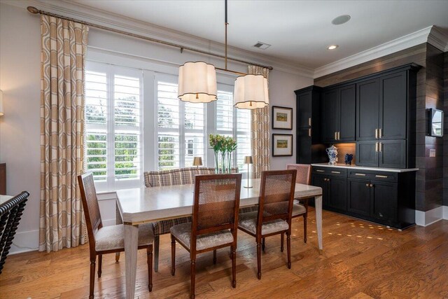 dining area with recessed lighting, light wood-style floors, visible vents, and crown molding