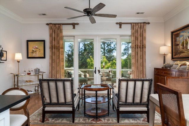 sitting room with wood finished floors, visible vents, a ceiling fan, ornamental molding, and french doors