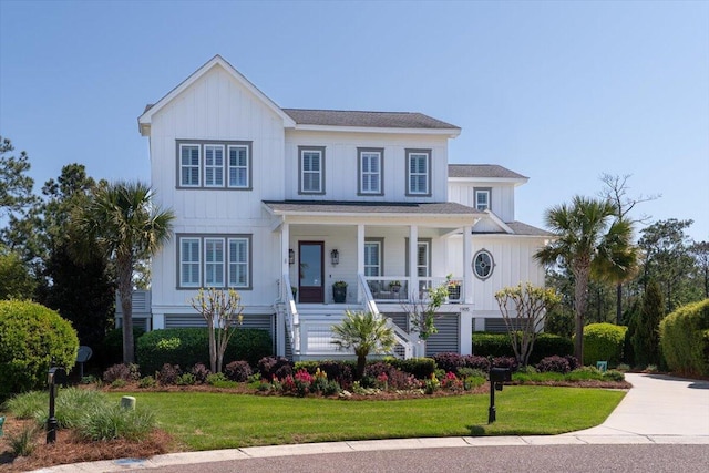 view of front of home with a front yard, covered porch, and stairs