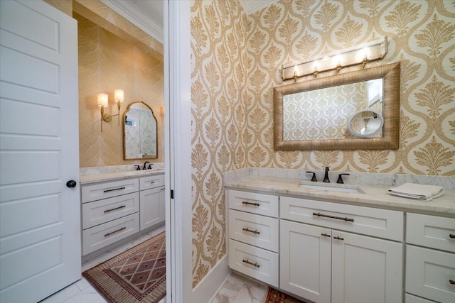 full bath with two vanities, a sink, and wallpapered walls