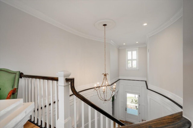 stairway featuring wainscoting, an inviting chandelier, recessed lighting, a decorative wall, and ornamental molding