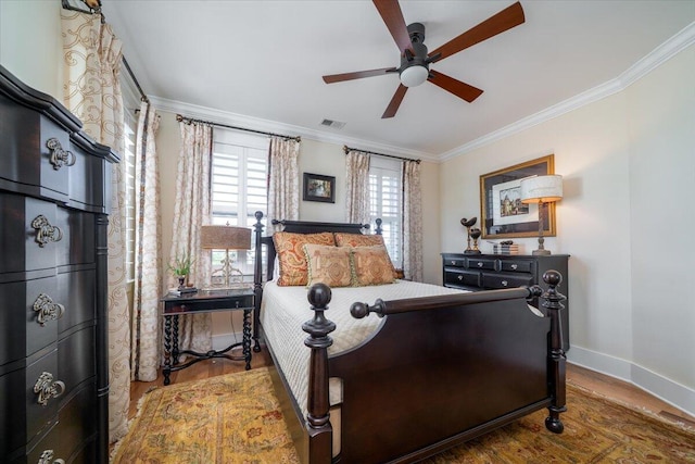 bedroom with visible vents, baseboards, wood finished floors, ceiling fan, and crown molding