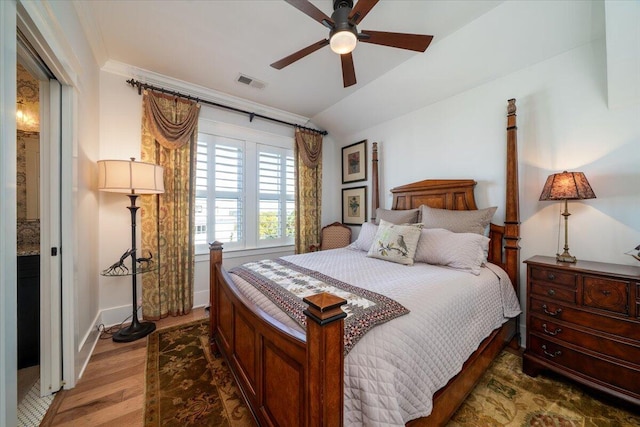 bedroom featuring wood finished floors, visible vents, crown molding, and ceiling fan