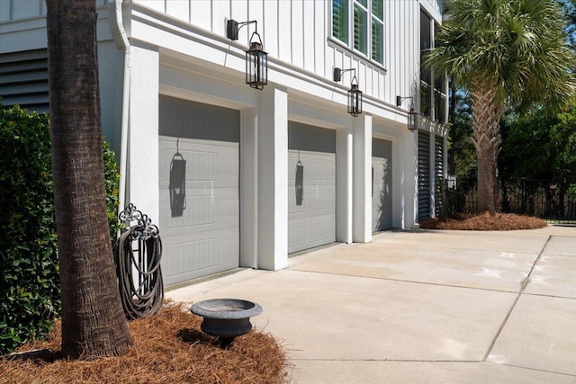 property entrance featuring concrete driveway, board and batten siding, and a garage