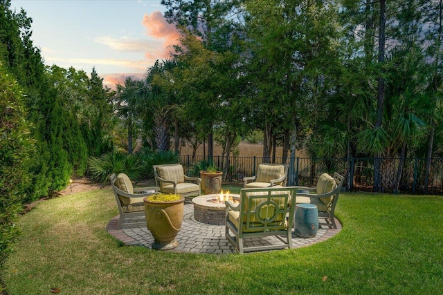 yard at dusk with a patio, an outdoor fire pit, and fence