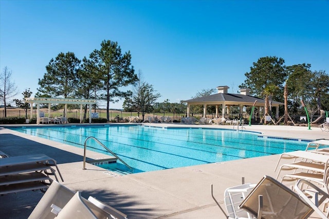 community pool with a pergola, fence, and a patio area